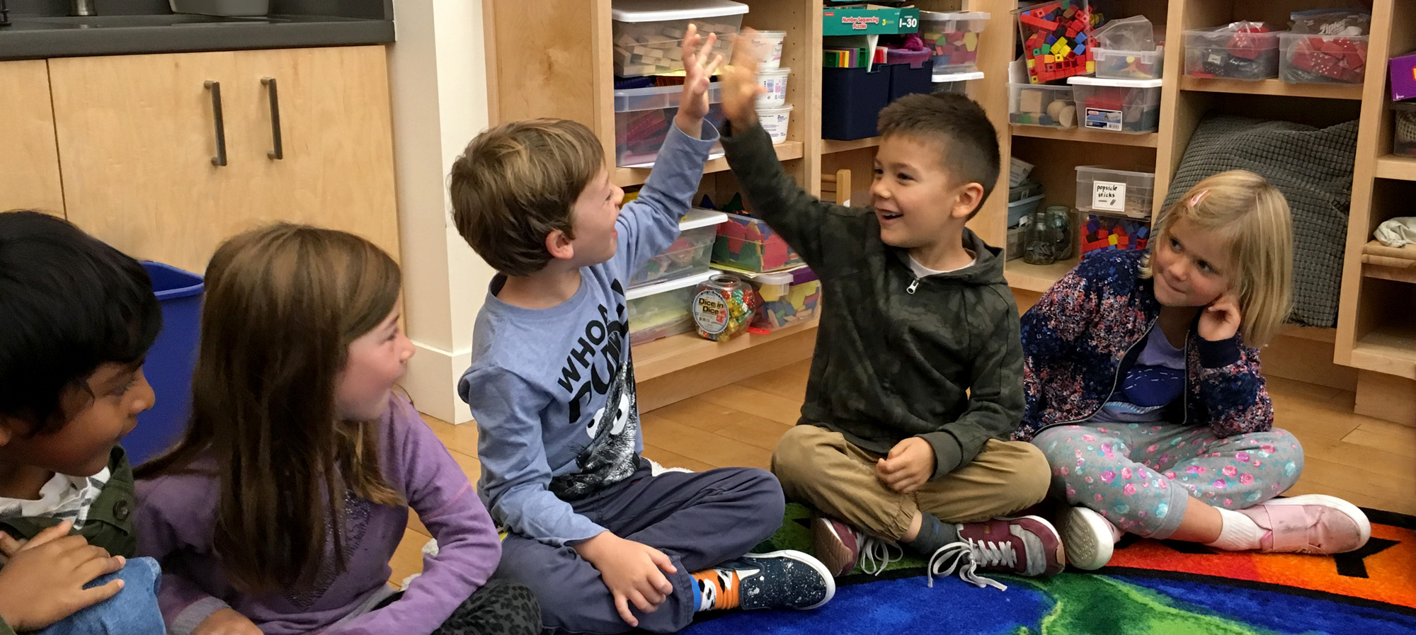 first graders in circle / high five